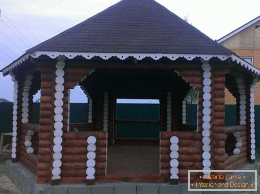 Структура лог куће је класична опција за украшавање дворишта дворишта земље.