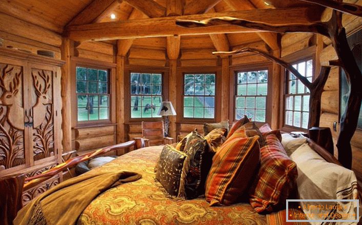 Једна од спаваћих соба у кући близу језера је израђена у стилу руралне земље. Дрвена декорација. Масивни намештај и декоративни елементи одабрани су у најбољим традицијама стила.