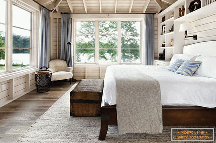Спаваћа соба у скандинавском стилу са великим брачним креветом од дрвета у кући француског бизнисмена.