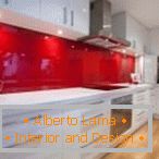 Бијели намештај и црвена бочица у унутрашњости кухиње
