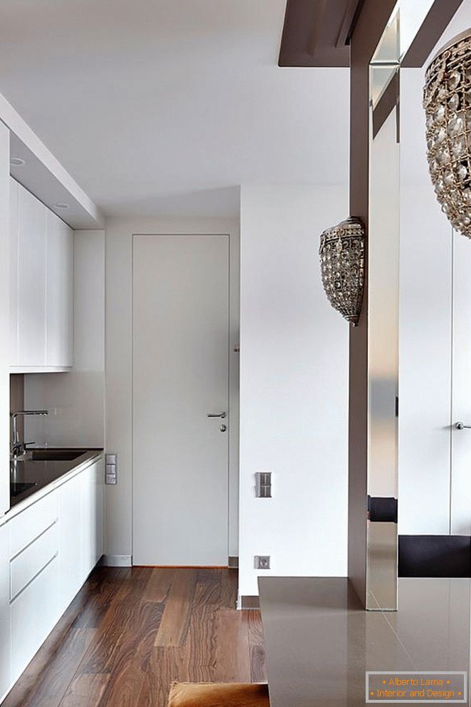 Бела кухињска гарнитура, бела улазна врата и прекрасан дрвени паркет