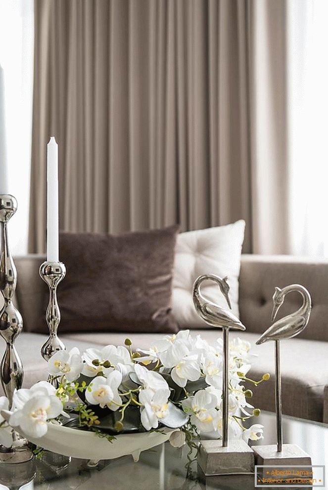 Састав орхидеја, свећа и других декоративних елемената на столу у дневној соби