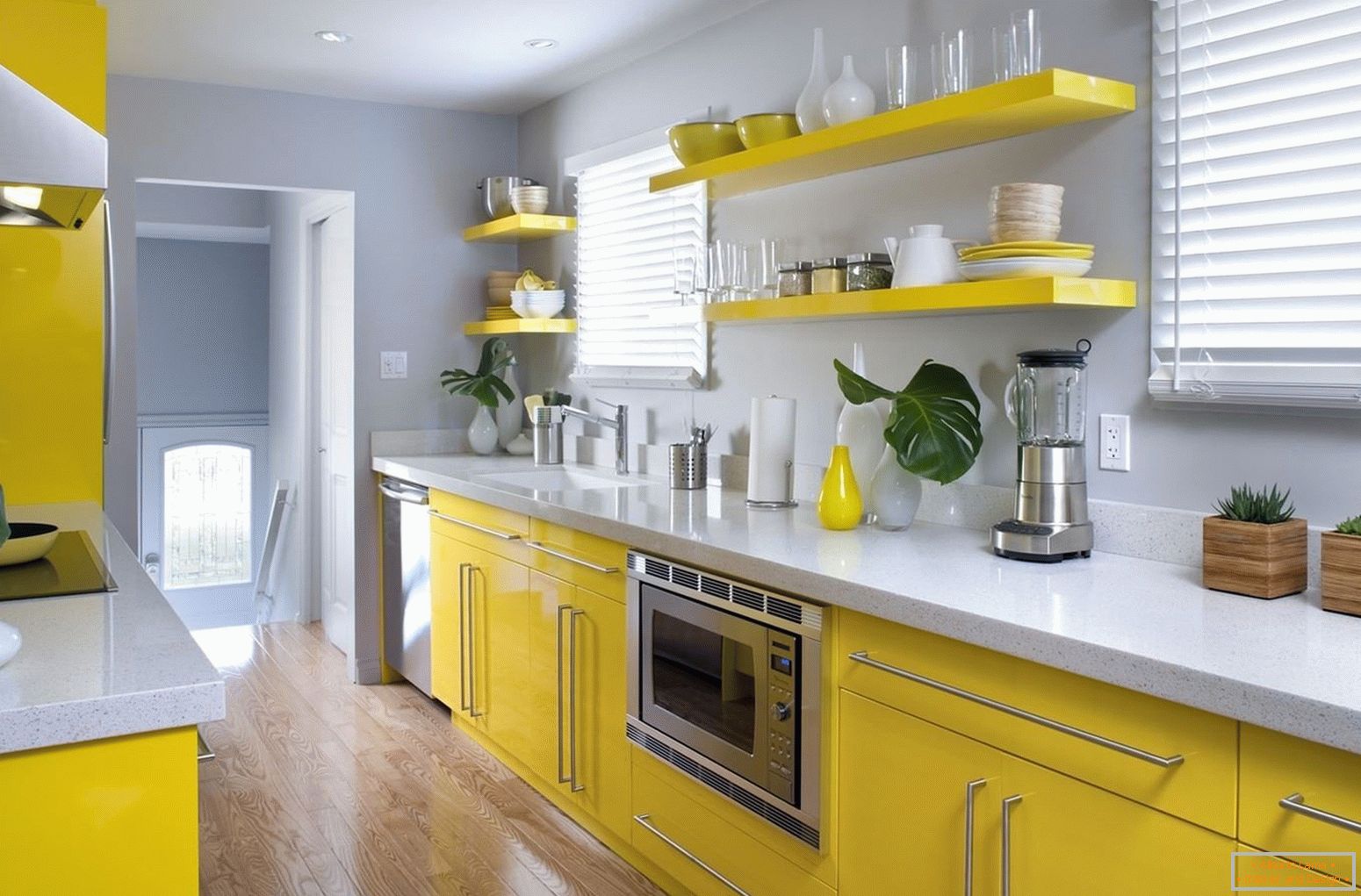 Комбинација жутог намештаја и сивих зидова у кухињи