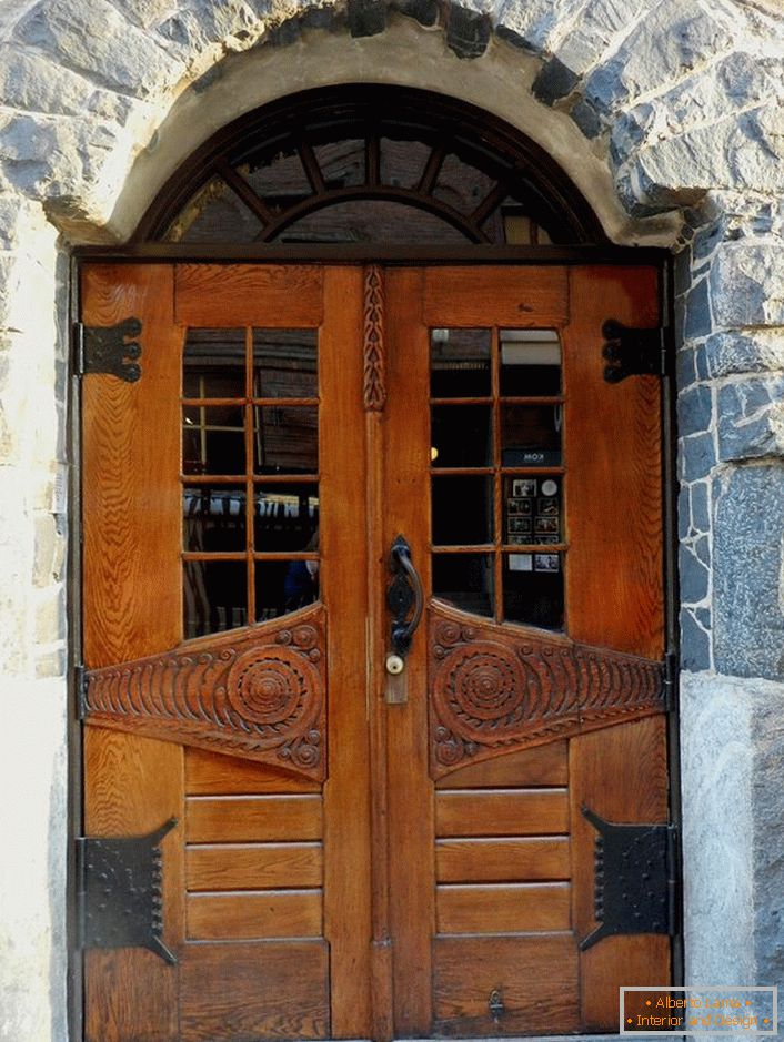 Врата у стилу Арт Ноувеау украсјују улазна врата једне сеоске куће са фасадом од природног камена. 