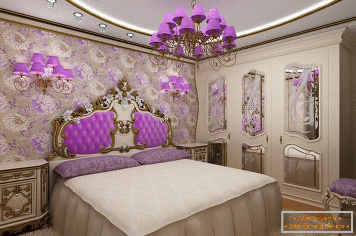 Елегантна барокна спаваћа соба са занимљивим акцентом на осветљење. Лустери и ноћни лампе са истим љубичастим нијансама хармонично спојене с тапацирром наслона у главу кревета.