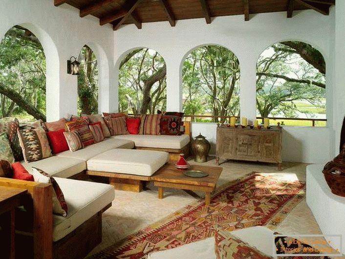 Веранда сеоске куће уређена је у складу са медитеранским стилом. Занимљива карактеристика је декор са пуно шарених јастука.