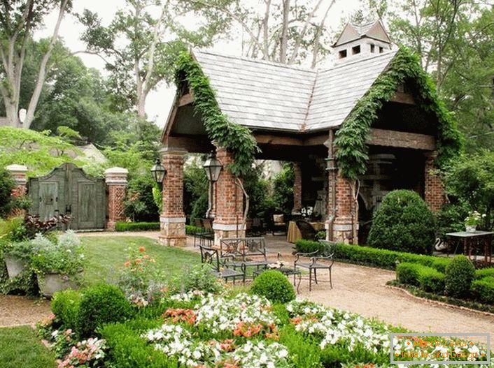 Елегантна једноставност отвореног сјенила у стилу планинарског дома изгледа органски у луксузној, угодној башти. 