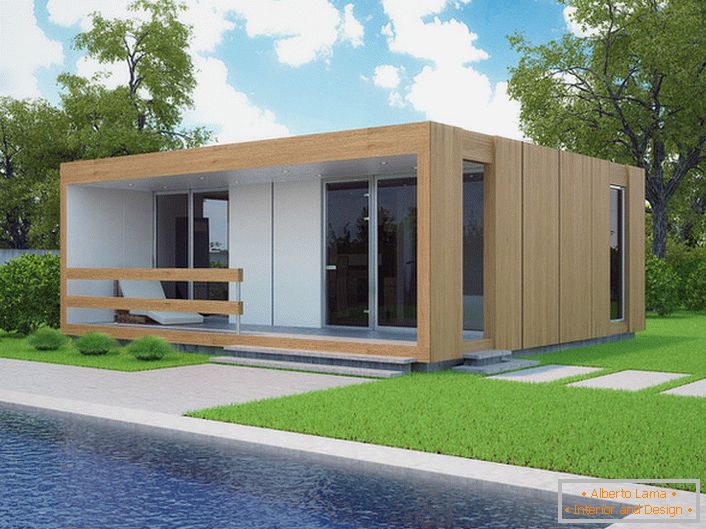 Мала модуларна кућа са базеном у дворишту. Модеран дизајн куће која се гради брзо изгледа органски на позадини краткотрајног травњака.