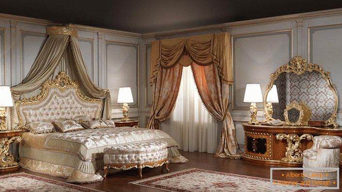 Огледало за велику спаваћу собу је правилно изабрано. Облик погрешног овалног изгледа одлично у оквиру златног резбареног дрвета.
