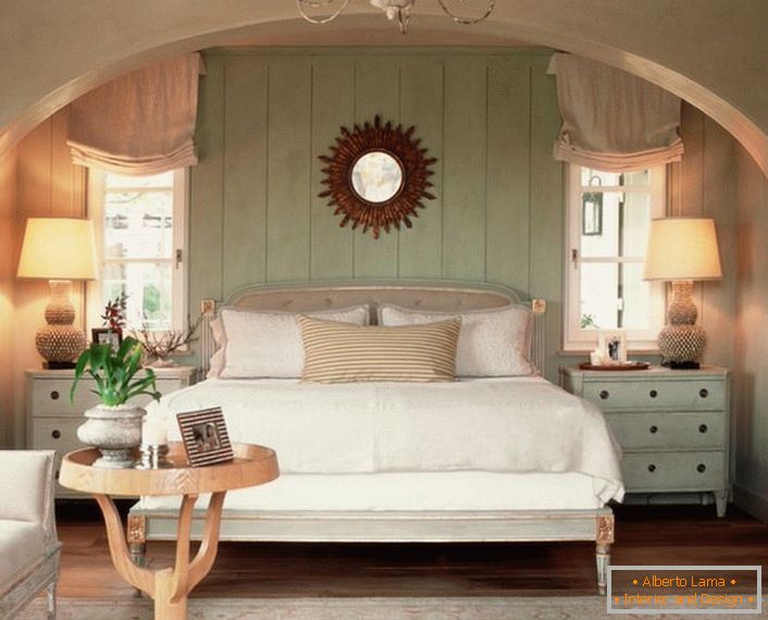 Породична спаваћа соба у стилу државе. Топлину куће, што је више могуће, наглашава меки, волуметрички кревет, прекривен јастуцима.