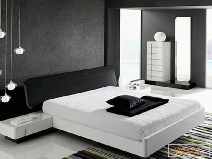 Зид на глави кревета, украшен сивим матим уметком, у складу са стилом хи-тецх је у сагласности са сјајним белим подом.