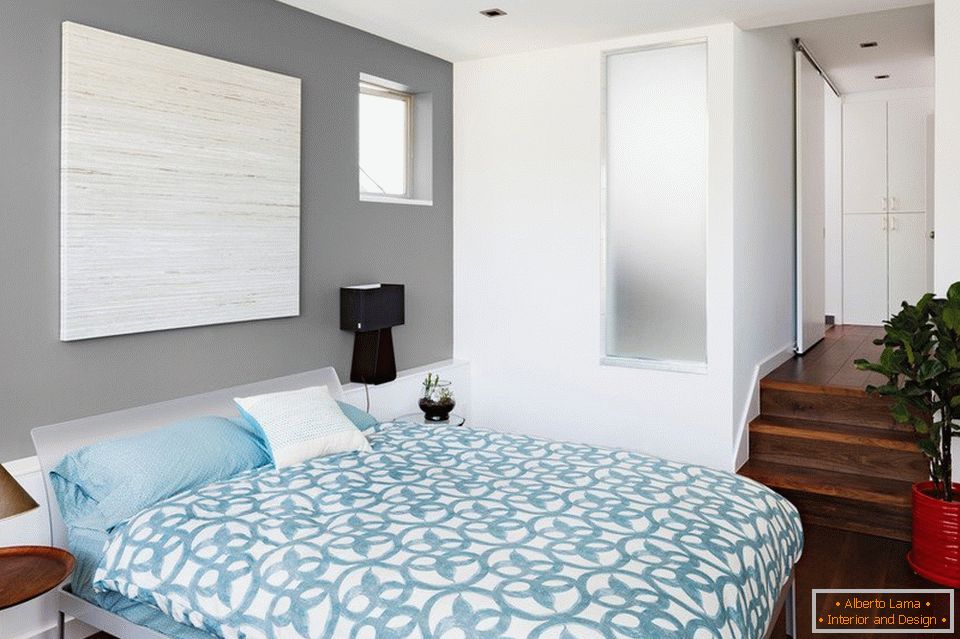 Плава постељина и сиви зидови у спаваћој соби