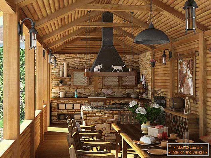 Мала кухиња са роштиљем на веранди сеоске куће. Цоунтри стиле је најприје доказан декорацијом зидова и плафона са дрвеним оквиром.